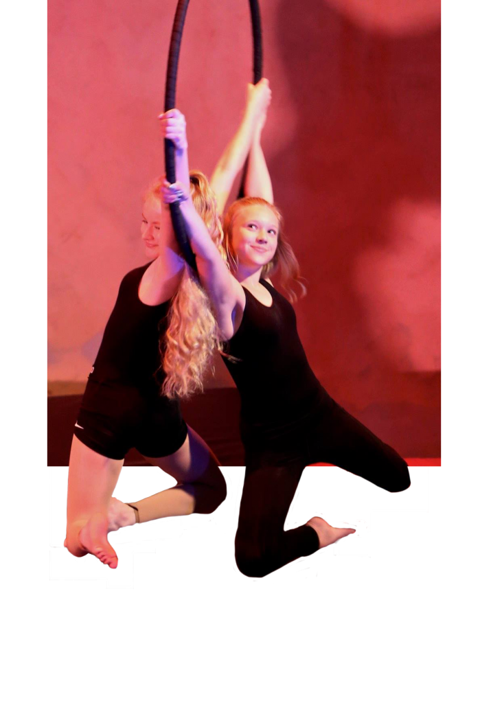 2 girls who are back to back hanging from a hoop. Their legs are cut out from the background to give the perception that you are seeing them in person.