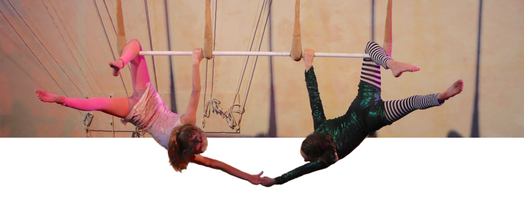 Two Students hanging from bars and holding hands